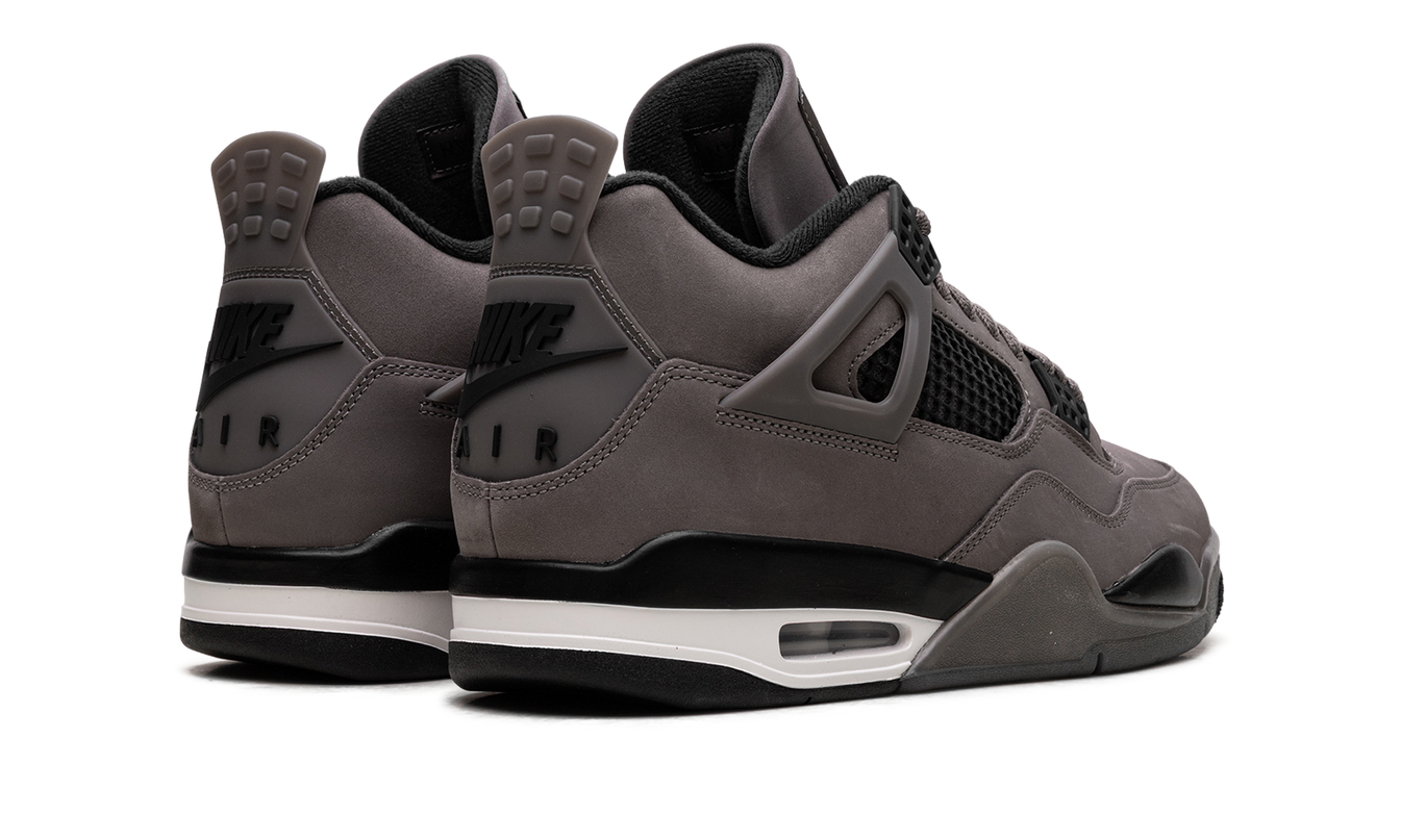 Lichte grijze Air Jordan 4 sneakers met cave stone details en witte accenten, zichtbaar in close-up.