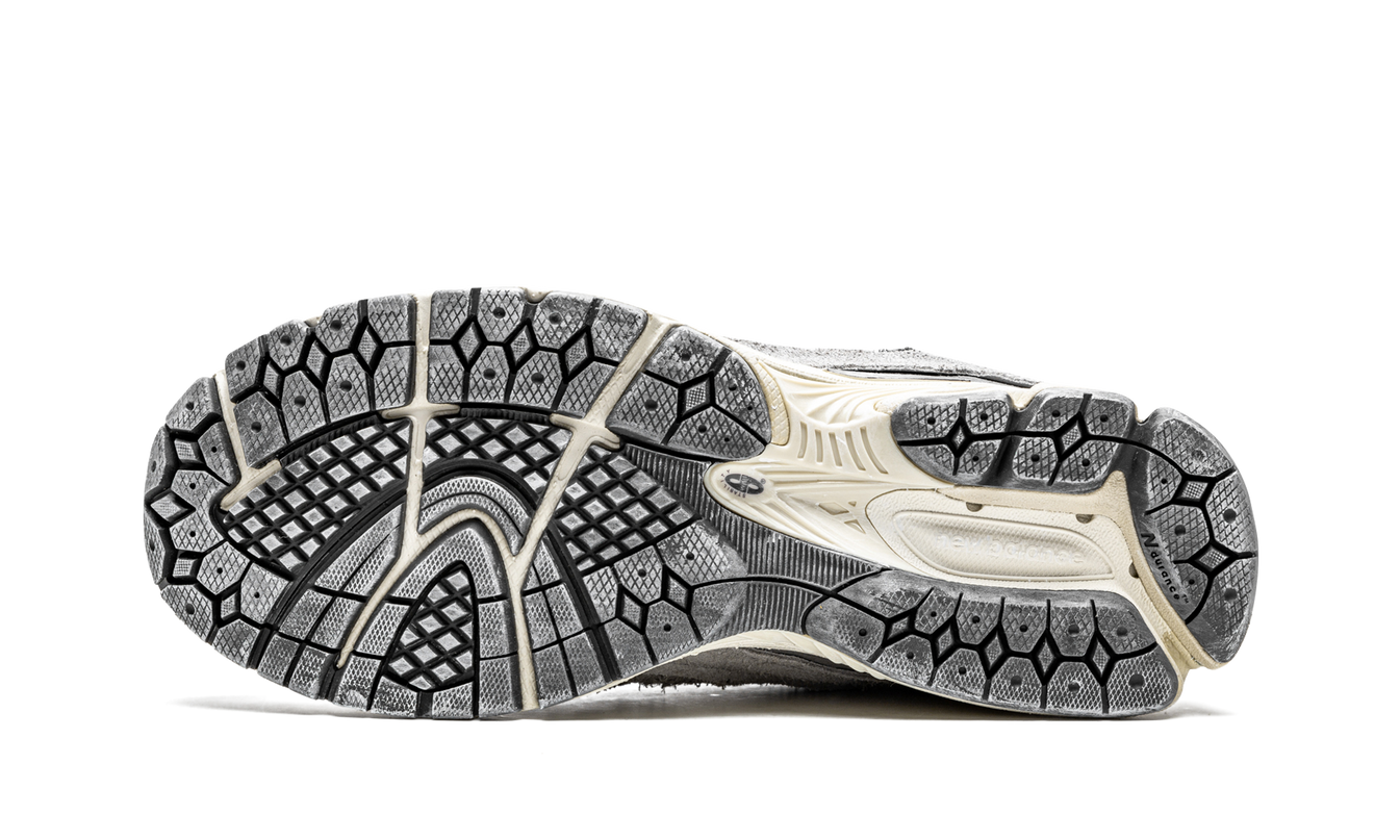 Grijze New Balance 2002R schoenen uit de Protection Pack, met gedetailleerde leren en mesh bovenkant.